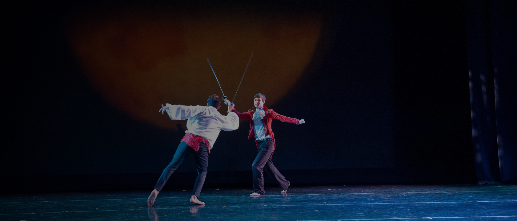 Two students sword fighting on stage